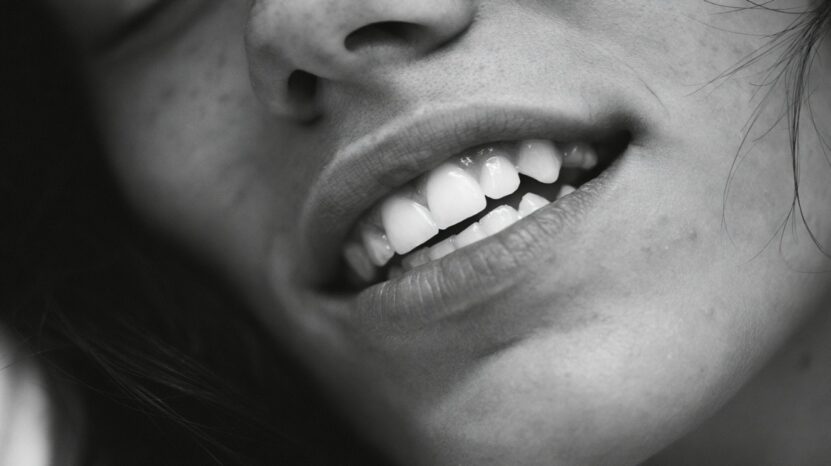 Close-up of a woman smiling and showing her teeth.